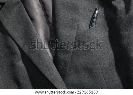 Grey color suit represent the formal uniform for businessman in the scene appear chrome ball pen also