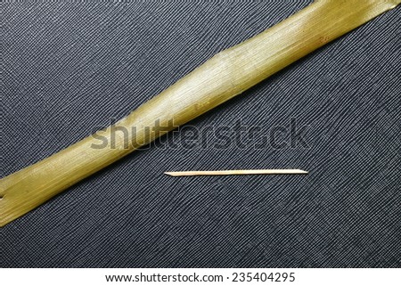 Banana leaf and small bamboo pin use for Thai traditional product packaging  to represent the basic idea of food containing material in the scene show the texture background of the leaf.