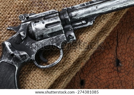 The artificial vintage plastic toy gun put on the brown color sack represent weapon concept related idea