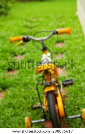Blurry focus of small size bicycle on the garden floor represent the bicycle concept related idea.