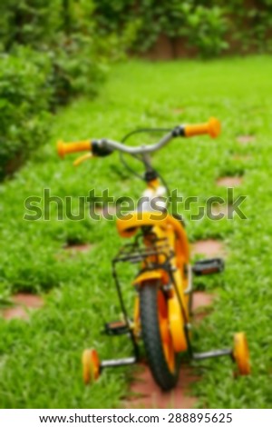 Blurry focus of small size bicycle on the garden floor represent the bicycle concept related idea.