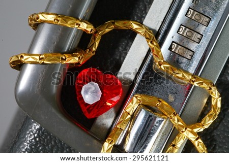 Old and dirty briefcase with gold necklace and plastic heart shape red color represent the business concept related idea.