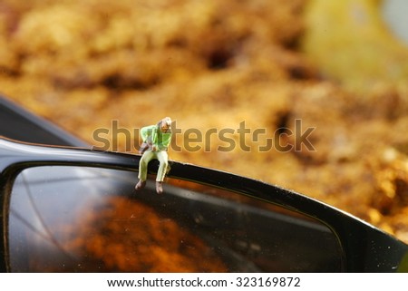The miniature figure model put on the lens part of sunglass represent the protective eyewear and model toy concept related idea.