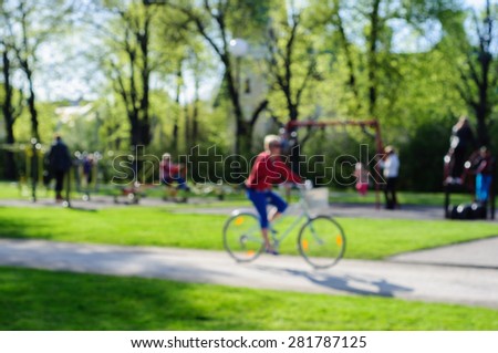Blurred summer scene in park with recreation people