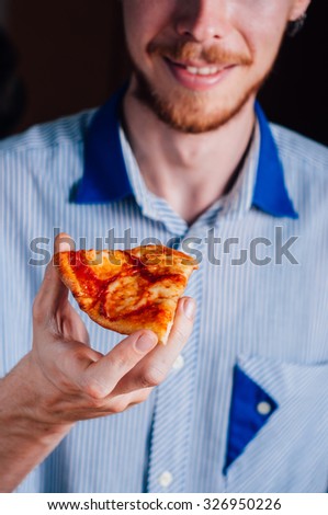 Young man with beard eating pizza Margherita Margarita