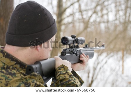 Soldier or hunter is aiming or shooting