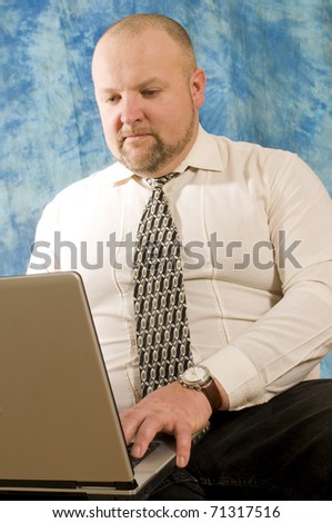 Man works on the computer against the blue background