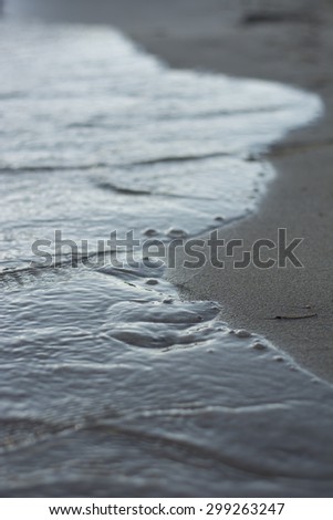 Footprints washed away by waves in the sand on the beach