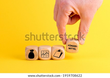A male's hand arranging wooden blocks with money, line graph, clipboard, and funding icons-concept for business growth process Photo stock © 