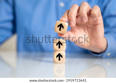A selective focus shot of a male's hand arranging wooden blocks with arrow going up sign-concept for business growth process Photo stock © 