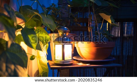A lantern glowing on a balkony surrounded by flowers Zdjęcia stock © 