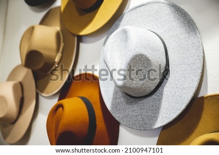 A closeup shot of cool hats in various colors hung on the white wall Foto stock © 