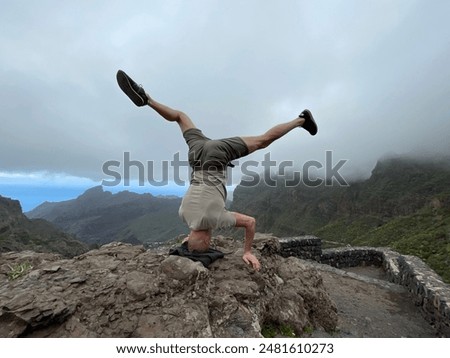 Similar – Image, Stock Photo Strong man performing handstand on sports ground