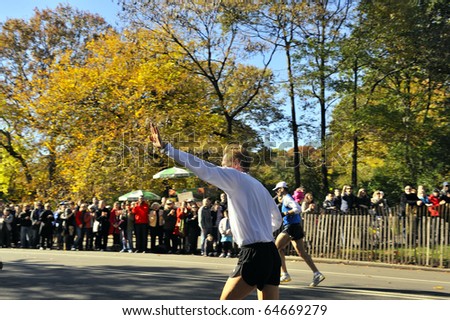 NEW YORK - NOV. 7: Unidentified runner waves to a cheering crowd in Central Park along the last few miles of the 2010 New York City Marathon in Central Park on Nov. 7, 2010 in New York, New York.