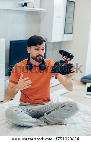 Similar – Image, Stock Photo Young man recording himself while playing guitar and singing to share the video in social media. Musician recording a music video at home.