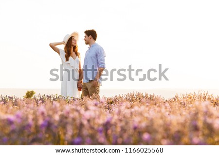 Photo of beautiful young people dating and walking together outdoor in lavender field