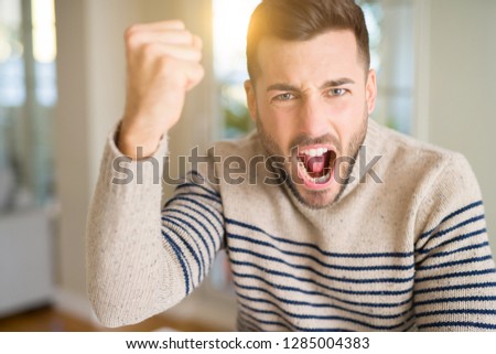 Young handsome man at home annoyed and frustrated shouting with anger, crazy and yelling with raised hand, anger concept