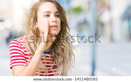 Beautiful young blonde woman over isolated background hand on mouth telling secret rumor, whispering malicious talk conversation