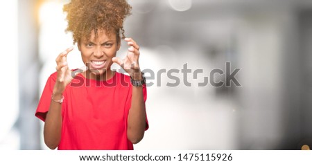 Beautiful young african american woman over isolated background Shouting frustrated with rage, hands trying to strangle, yelling mad