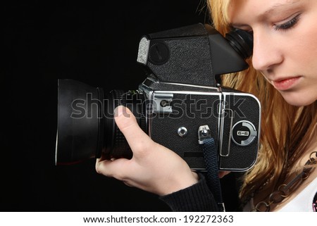 Attractive blonde girl photographing with medium format camera