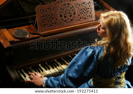 Baroque woman playing on an old grand piano
