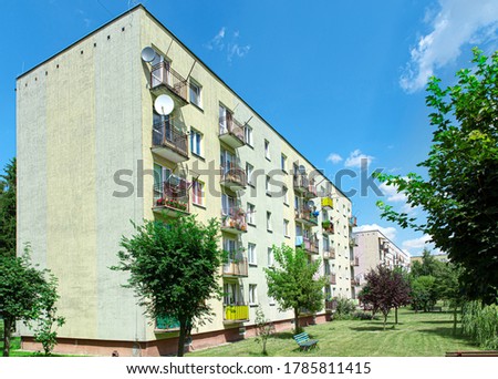 Green elevation and colorful facade of block of flats in housing estate. Urban landscape of housing blocks with laundry on balconies, Poland