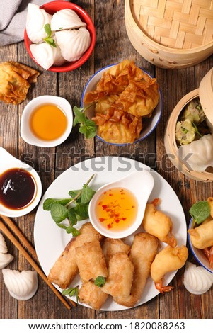 selection of asia food- spring roll, dim sum, fries shrimp and sauce