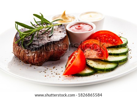 Barbecue beef steak with fresh tomatoes and cucumbers, mustard, mayonnaise and ketchup on white background 
