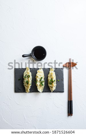 Kimchi dumplings Chinese snacks meat dumplings on black stone plate over white textured background top view space for text nobody
