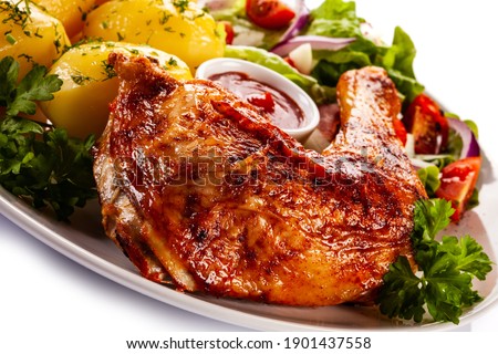 Roast chicken leg with boiled potatoes on white background 