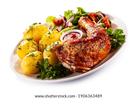 Roast chicken leg with boiled potatoes on white background 