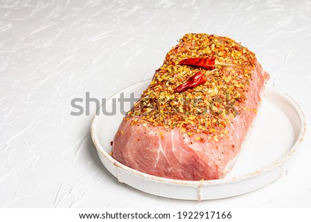 Raw organic meat. Pork fillet for grilling, baking or frying. Flakes spices, ceramic plate on white putty background, copy space