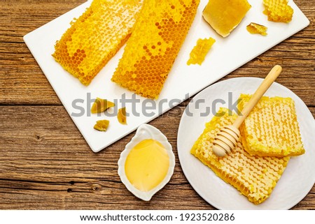 Honeycomb, honey and beeswax. Natural organic beekeeping products for a healthy and beauty lifestyle. Old wooden boards background, top view