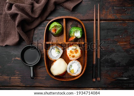 Homemade Sushi Bento Box with Sushi Rolls set, on old dark wooden table background, top view flat lay
