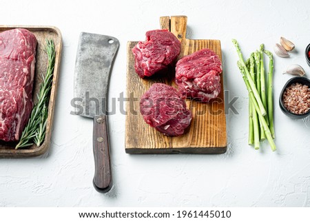 Beef fillet cut raw with ingredients set, on white stone background