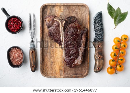 Prepared grilled large t bone steak set, on wooden tray, top view flat lay