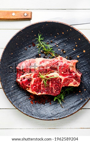 Raw beef meat with rosemary and spices.Uncooked beef steak