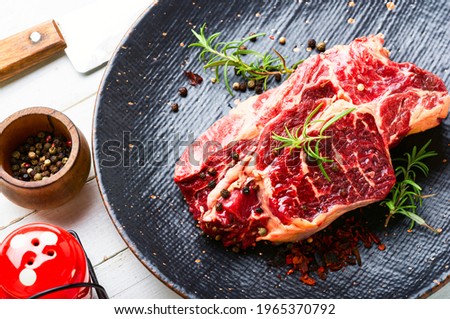 Raw beef meat with rosemary and spices.Uncooked beef steak