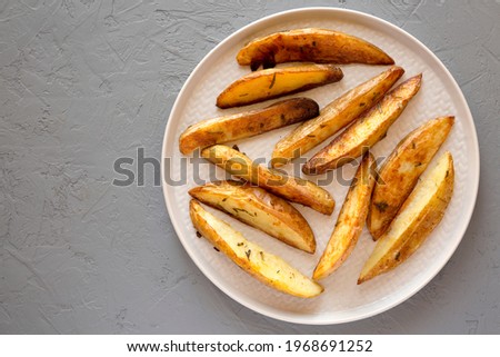 Homemade Rosemary Potato Wedges on a plate, top view. Flat lay, overhead, from above. Space for text.