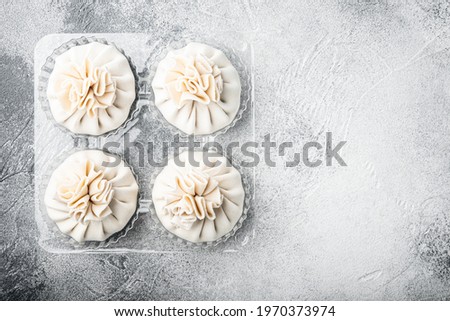 Raw dumplings Dim Sum set, in plastic tray, on gray stone background, top view flat lay, with copy space for text
