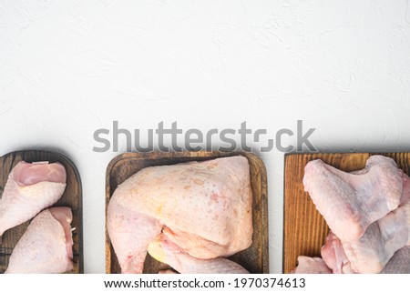 Raw uncooked chicken legs, drumsticks set, on wooden cutting board, on white background, top view flat lay, with copy space for text
