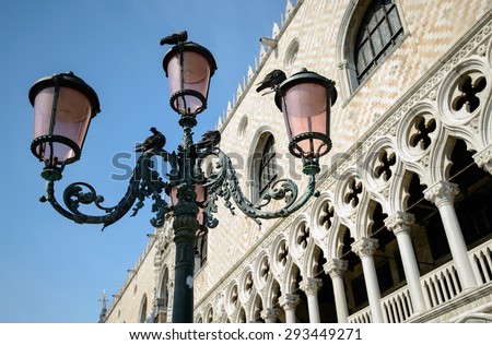Doves sitting on the lantern in front of the facade of Doge's Palace in Venice