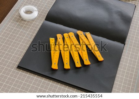 yellow ruler on black book with cutting matt