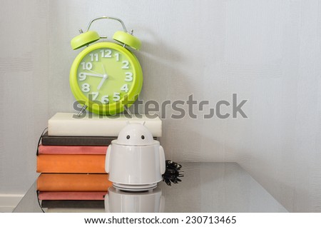 modern green alarm clock on books at home
