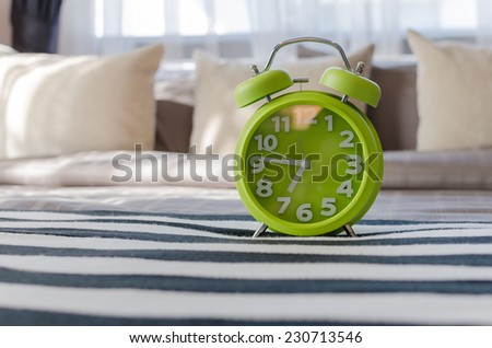 modern green alarm clock in bedroom at home