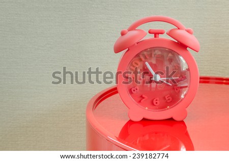red alarm clock on red table