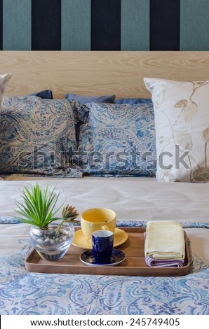 wood tray of tea cup and plant on bed at home