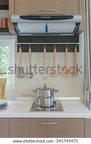 stainless pan on gas stove with hood in kitchen