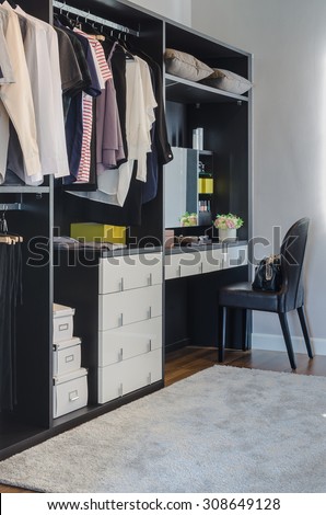 dark color scheme modern walk in closet design with black chair at home