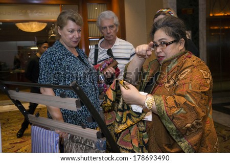 KUALA LUMPUR, MALAYSIA-JUNE 6,2013: Meike Sahala(R) explaining about batik to delegates in exhibition during Global Summit of Women 2013 in Kuala Lumpur, Malaysia on June 6, 2013.